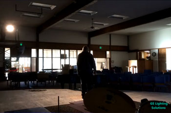 person working on stage with a white spot light on him inside First Baptist Church of Kent - Kent, WA, USA