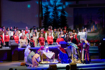 Live Nativity scene with a gobo pattern of a blue star in front of Christmas trees Journey to the Manger Musical - South Orlando Baptist Church, Orlando, FL, USA