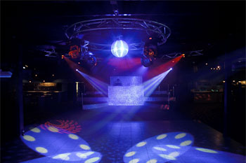 dance floor with illuminated disco ball with white light, 4 white beams of light projecting  geometric circles gobos, and red beams of light projecting geometric swirl of lines gobos from Techni-Lux Trackers  Aqua Lounge, Daytona Beach, Florida