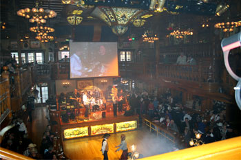 upperstairs view of band and dance floor with people line dancing while crowd watches on both floors inside Cheyenne Saloon - Orlando, Florida, USA