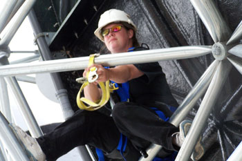 consultant Lisa Hansen harnessed on geometric triangular metal patterns around the funnel portion of Brainwash Water Slide, Wet 'n Wild - Orlando, Florida, USA